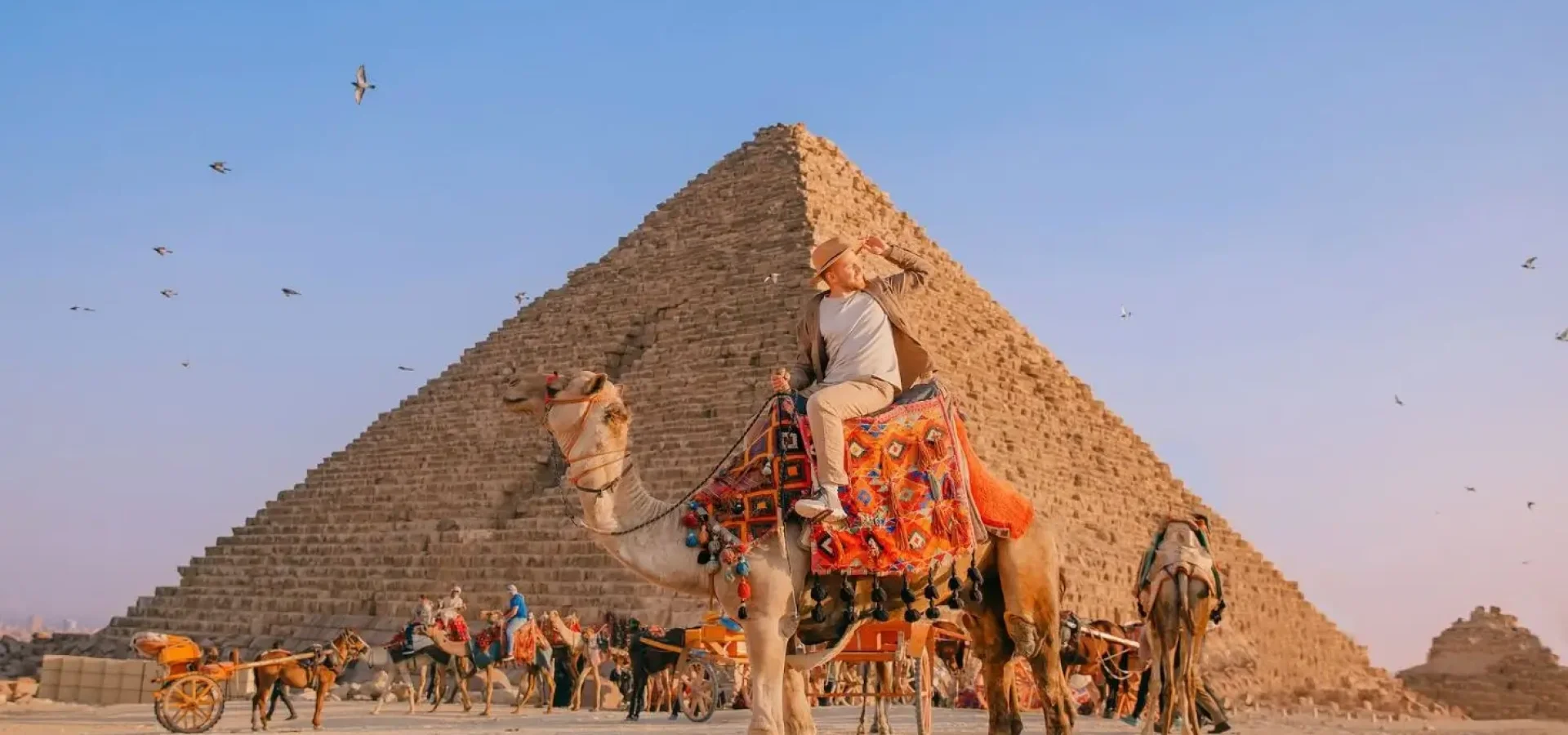 A camel ride at the Giza Plateau during sunset, highlighting essential Egypt travel tips for iconic sightseeing in Cairo