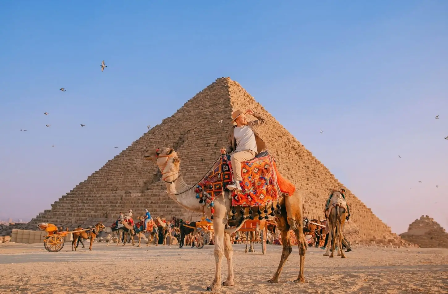 A camel ride at the Giza Plateau during sunset, highlighting essential Egypt travel tips for iconic sightseeing in Cairo